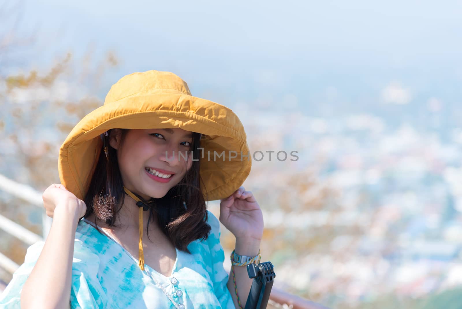 Asian pretty cute woman with hat relax at seaside city landscape viewpoint on mountain with happy and freedom emotion in concept travel, vacation, leisure in life