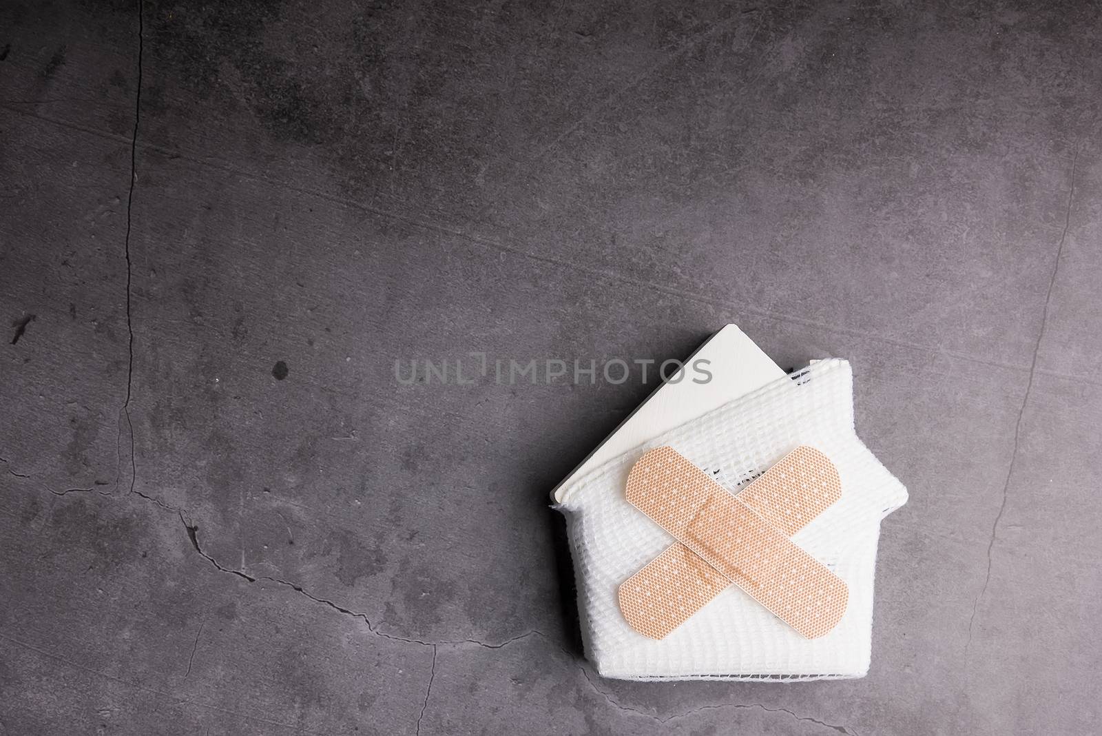 Wooden model white houses and first aid equipment on a cement gray background. Concept home repair, Home improvement, Renovate home.