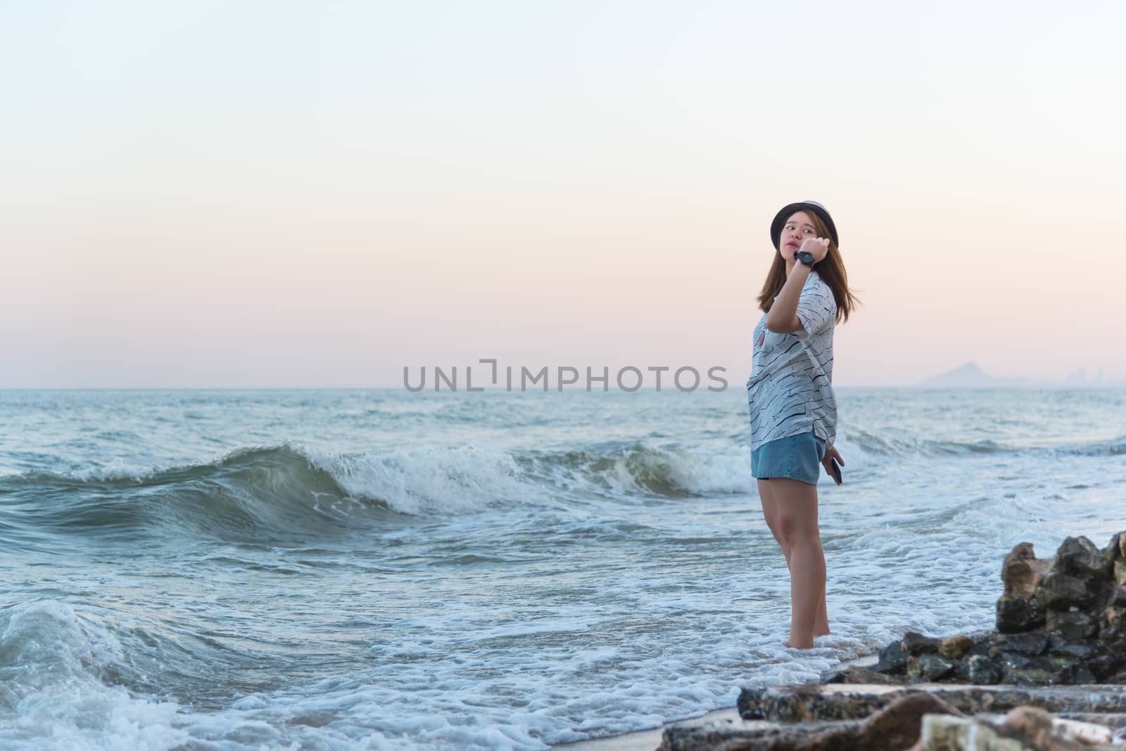 Asian pretty cute woman relax at sea beach with happy and freedom emotion in concept travel, vacation, leisure, fun in life