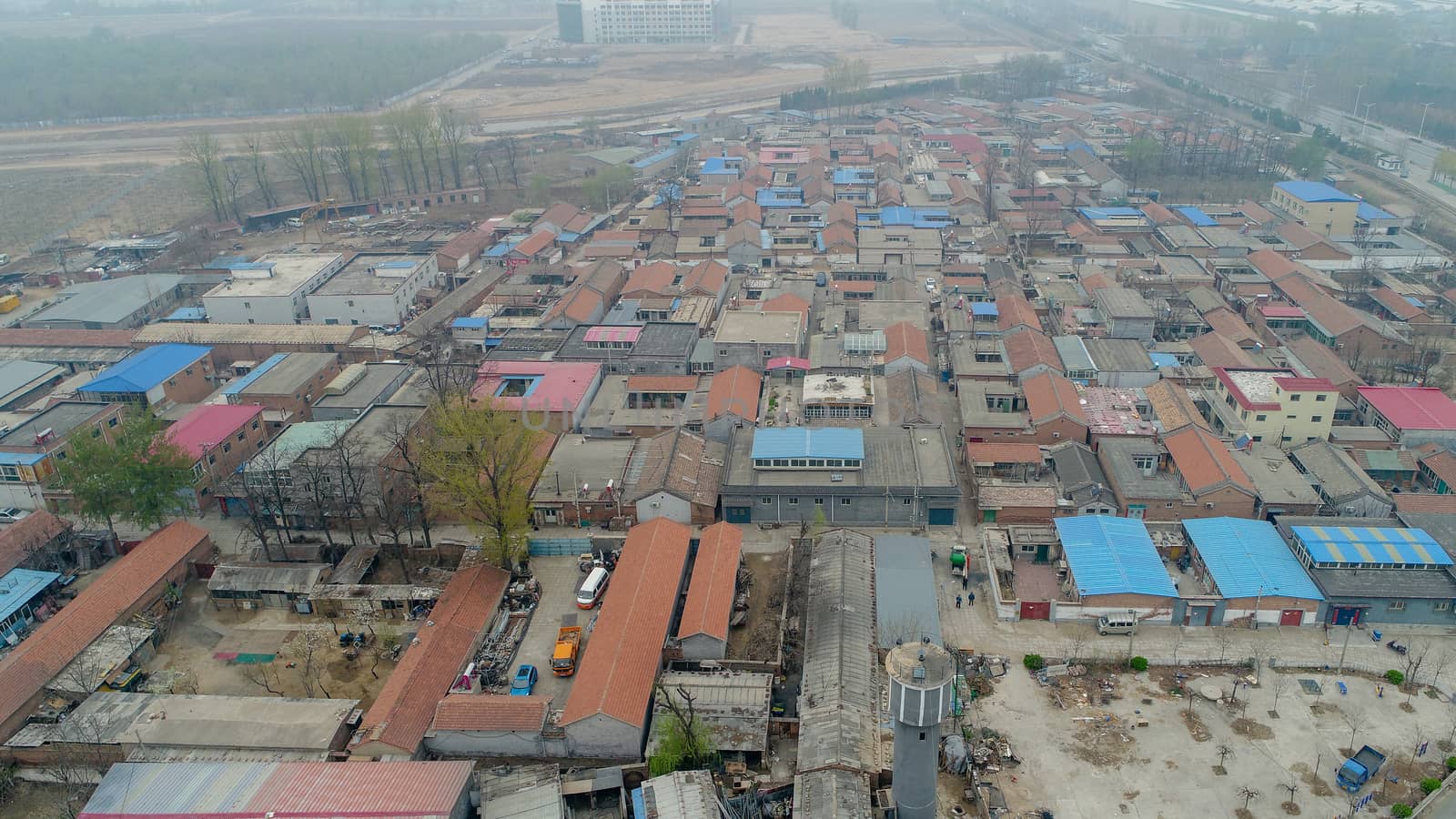 Rural poor village outside Beijing with farmland and train tracks during extreme pollution day by Bonandbon