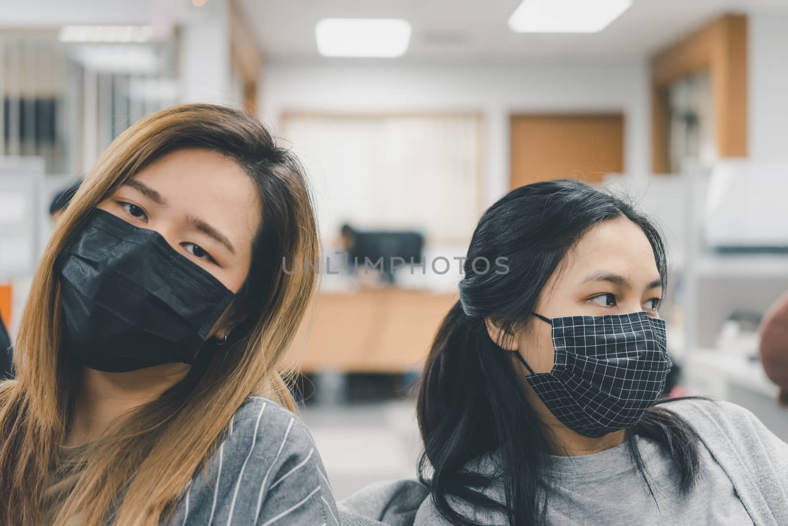 Asian pretty women wearing mask respiratory protection mask against epidemic flu covid19 or corona virus from wuhan in office with fear emotion in concept illness, outbreak, healthcare in life