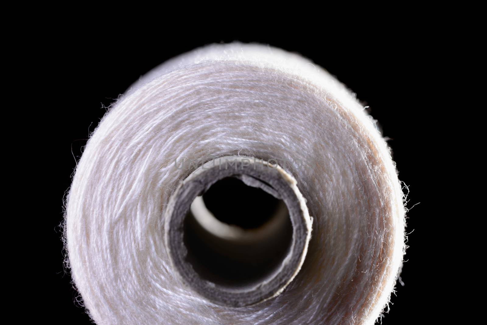 Macro of a white thread roll on black background