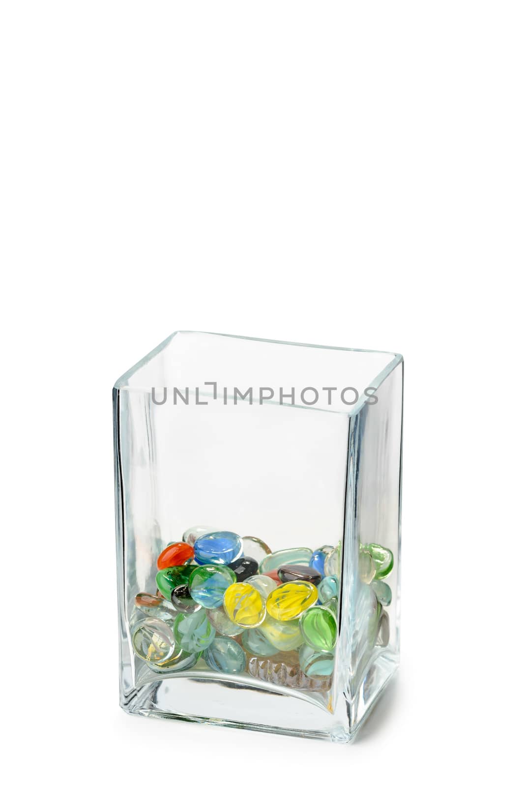 A Parallelepipedic transparent crystal vase isolated on white background, half full of colored glass beads