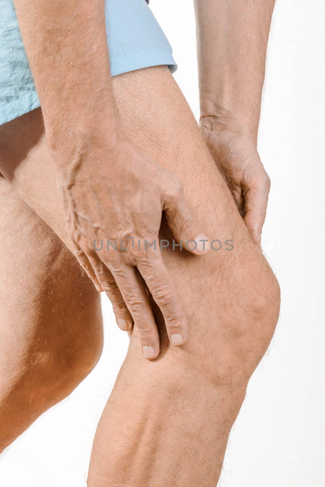 Athlete man massaging a painful  quadriceps and the knee after a sport accident. It could be a musculaire claquage, a muscle elongation or an iliotibial band syndrome