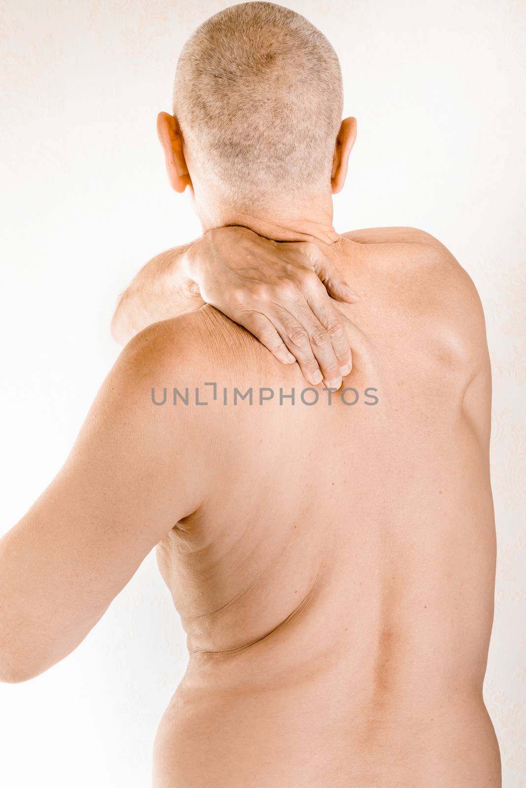 Man massaging his top back, the trapezius muscle, because of a thoracic vertebrae pain due to a displacement of a dorsal vertebra rubbing on a nerve