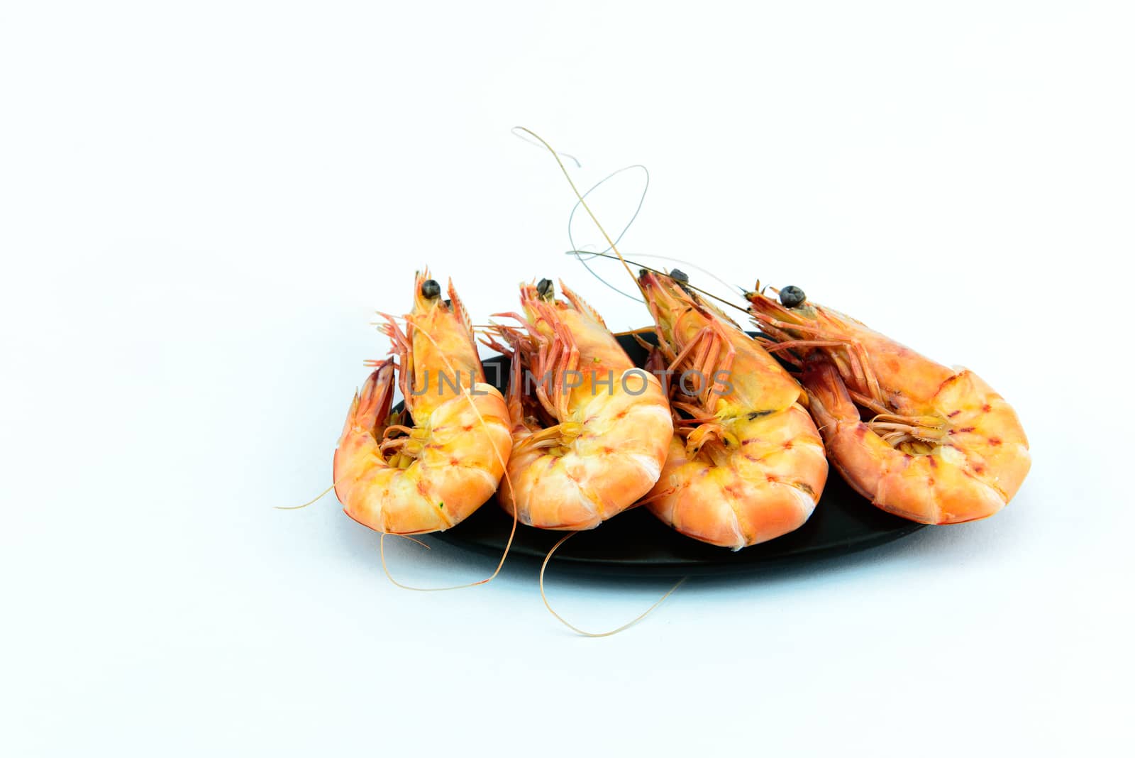 Boiled shrimp and black plate on white background	