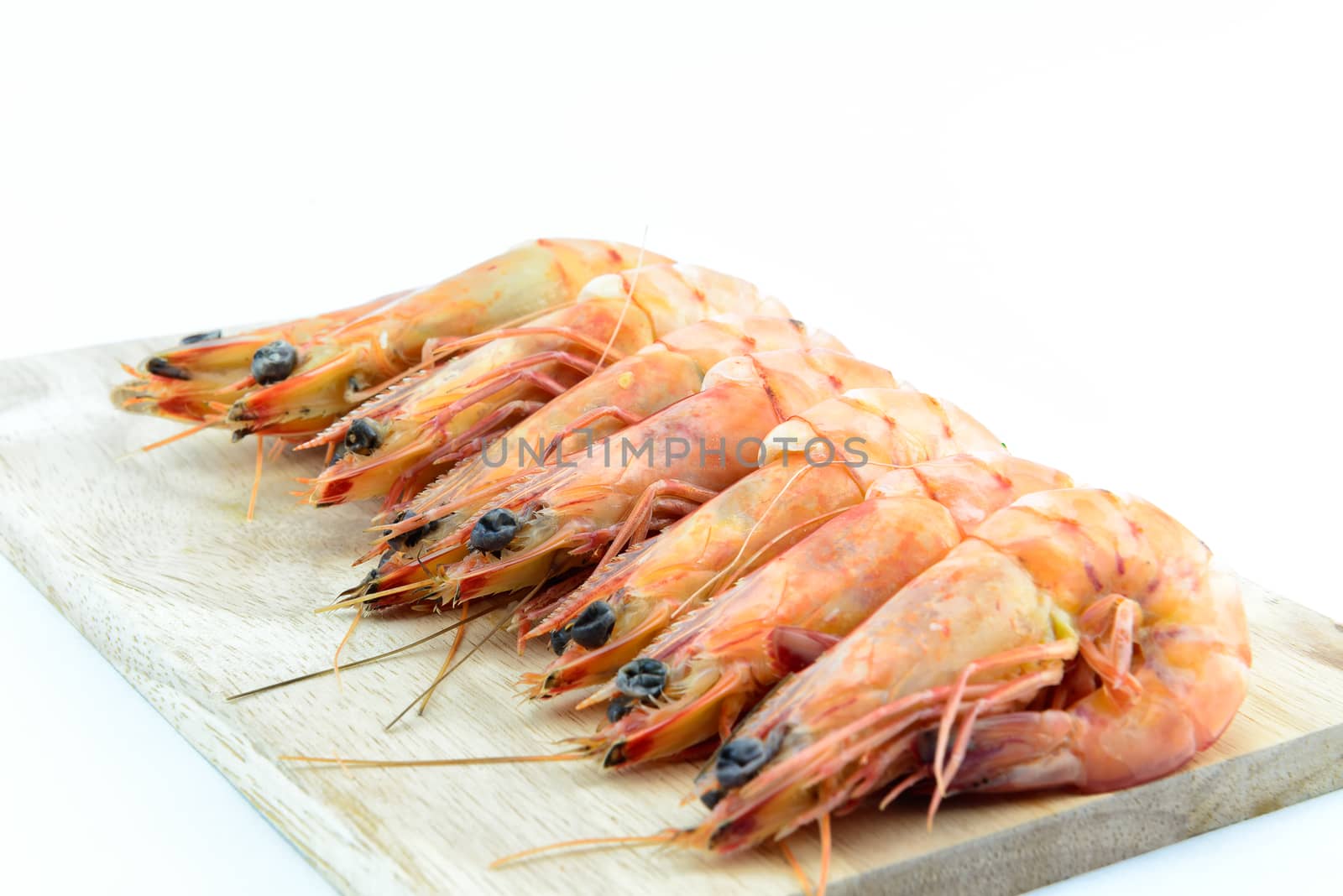Boiled shrimp on wooden board on white background