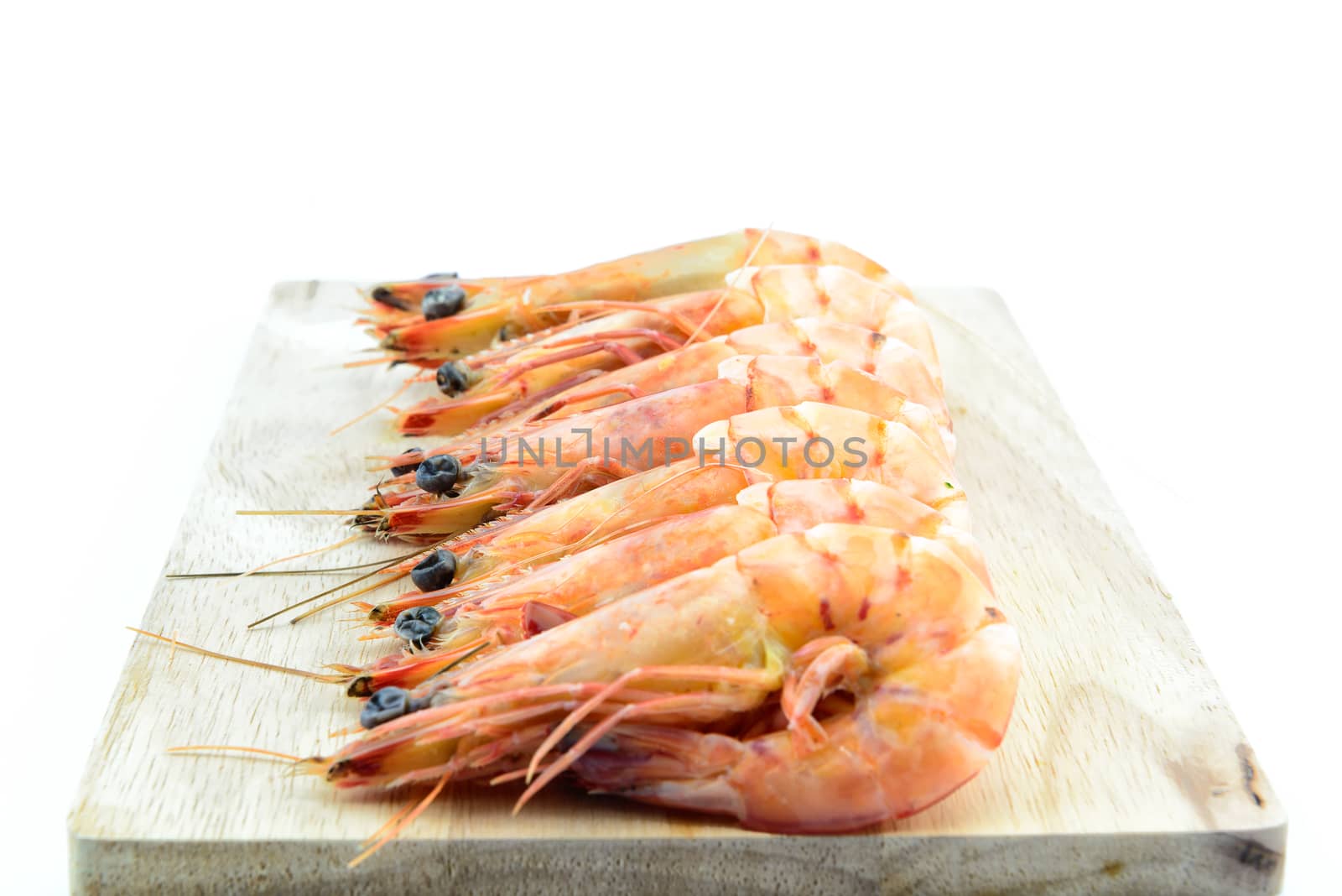 Boiled shrimp on wooden board on white background by YingTanthawarak