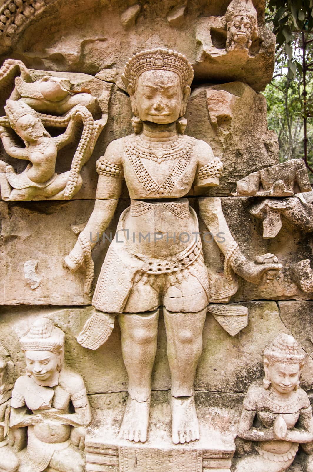 Stone carving of a hindu god. Ruins of Ta Prohm temple, Angkor, Cambodia.