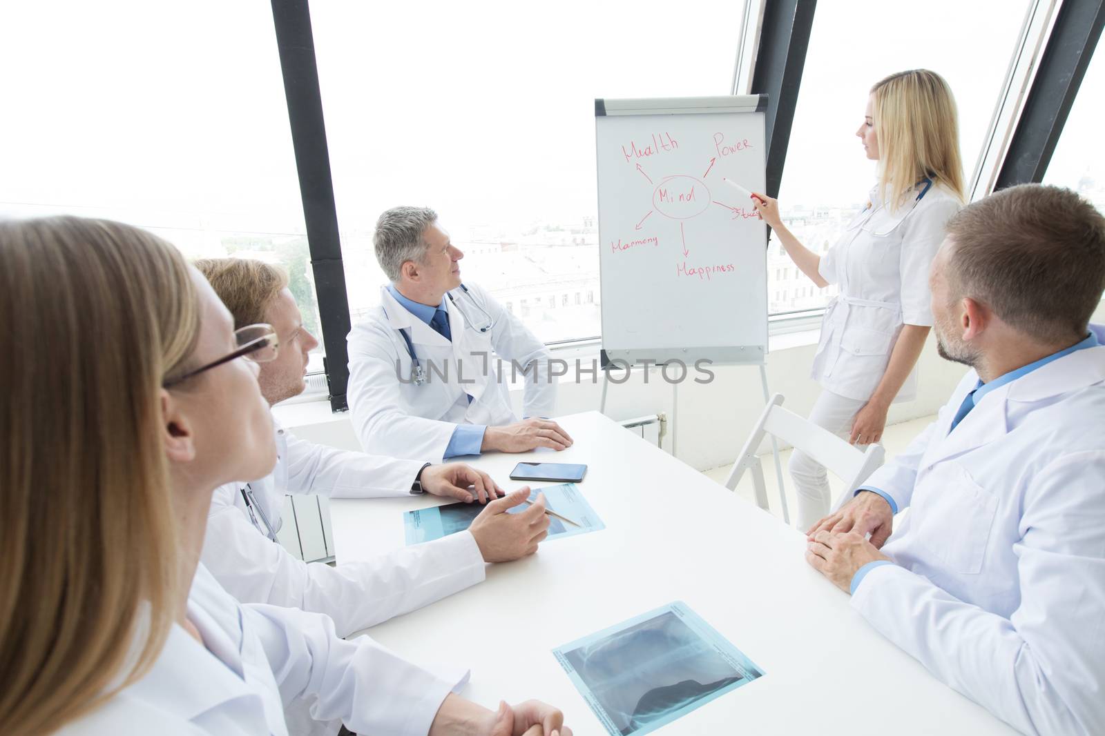 Team of medical doctors discuss mental health concept at presentation in clinical office