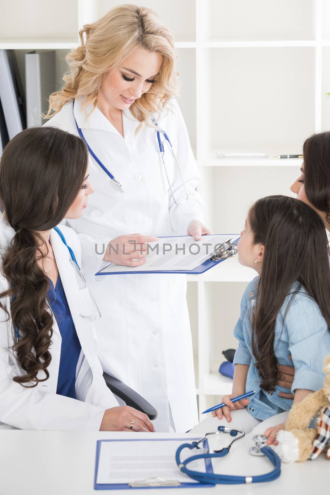 Young mother and girl in pediatrician office, doctor giving diagnosis and prescription