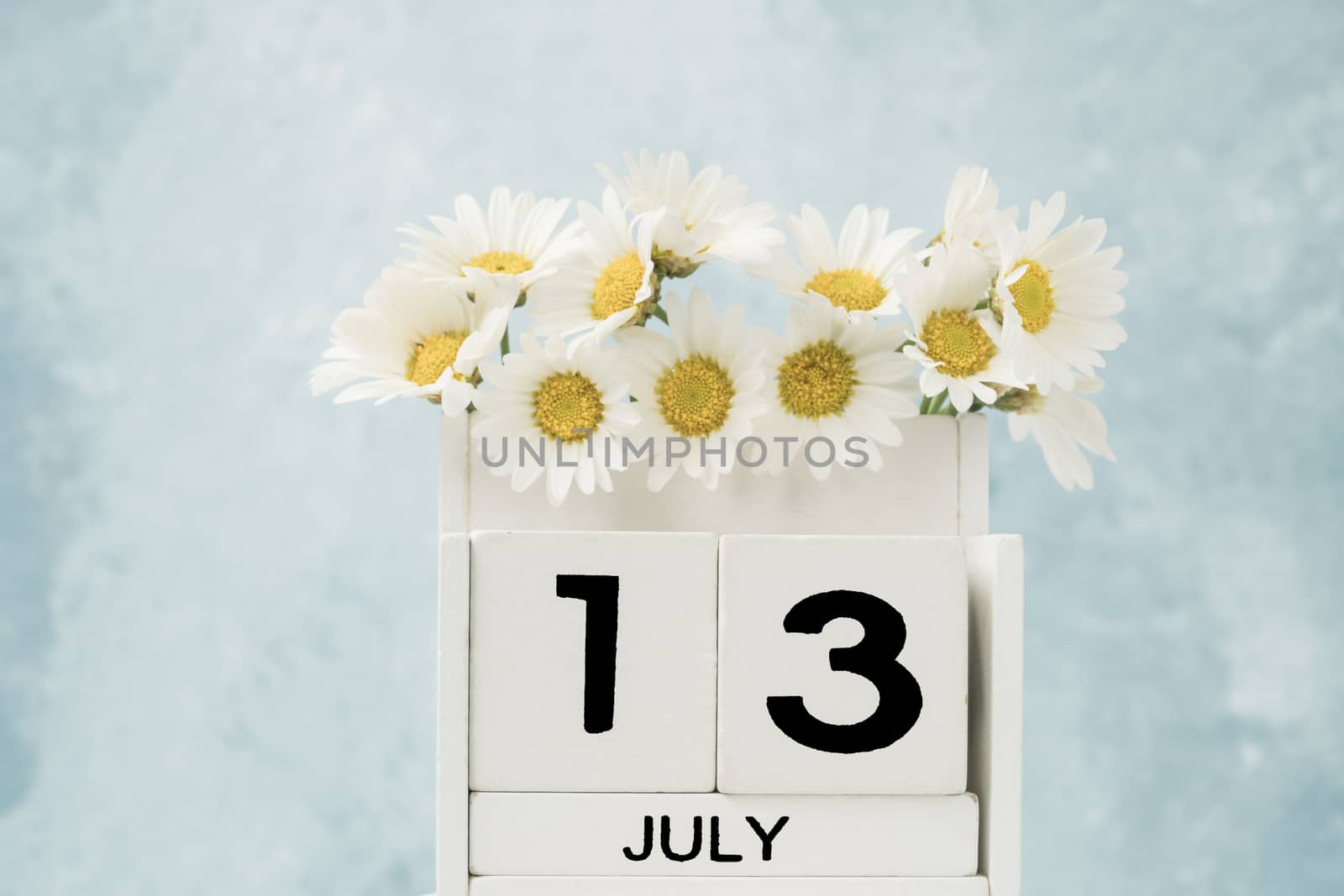 White cube calendar for july decorated with daisy flowers by bernanamoglu