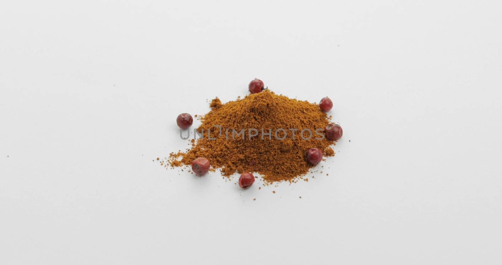 Red pepper powder. Red herbal spice, aromatic seasoning for food preparation and cooking, macro shot against a white background