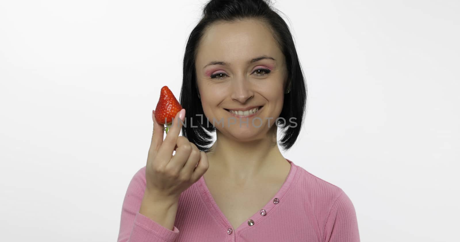 Young beautiful woman with fresh and juicy strawberry. Healthy nutrition