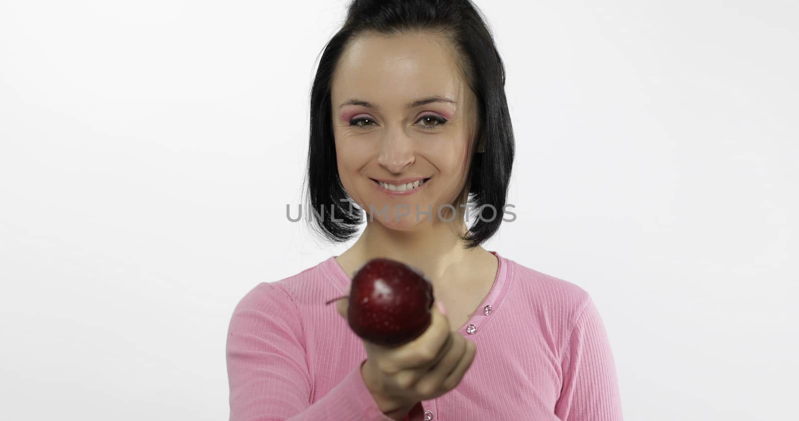 Young beautiful with red apple offer bite to viewer. Healthy nutrition.