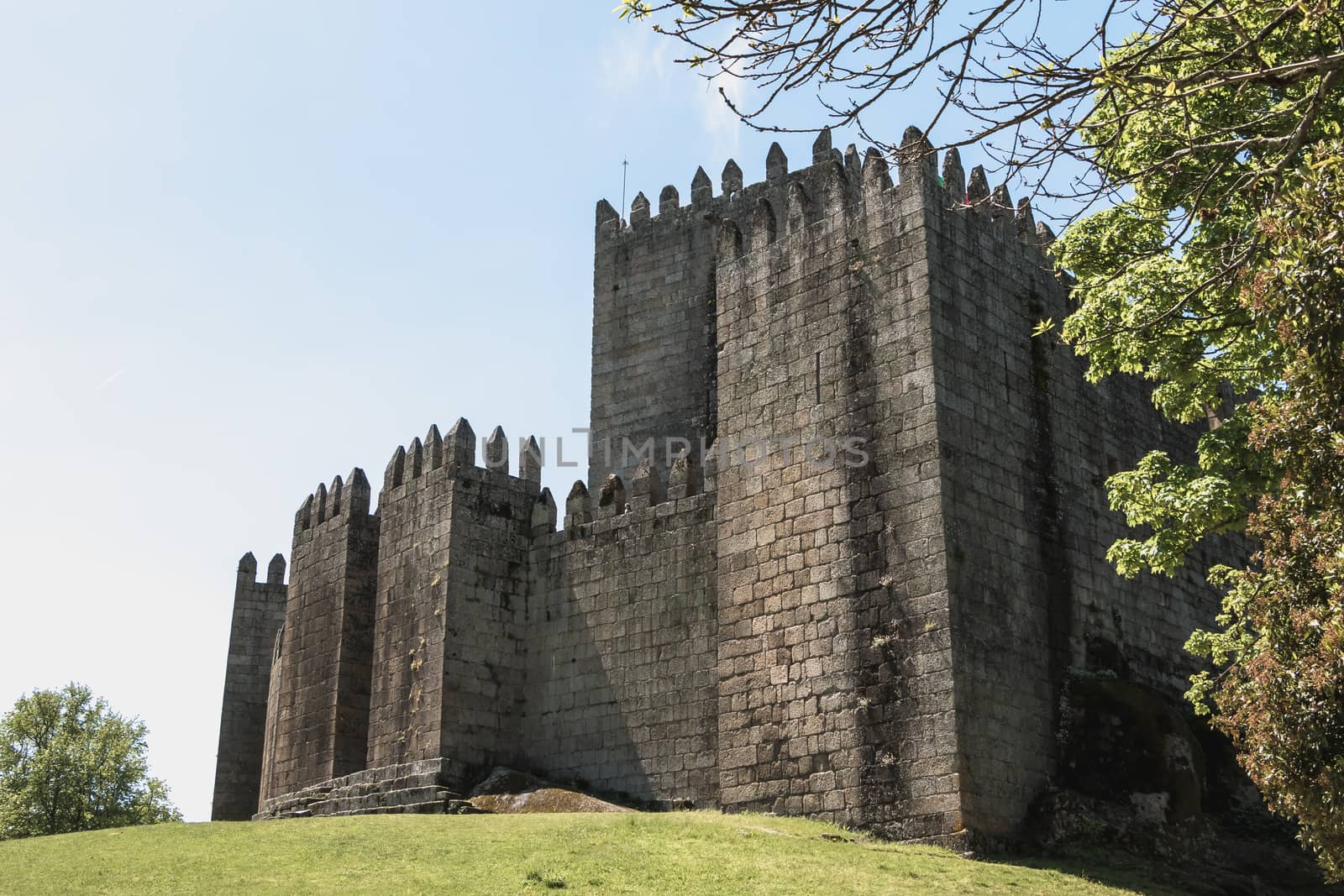 Guimaraes, Portugal - May 10, 2018: Architectural detail of the Guimaraes Castle that tourists visit on a spring day. Medieval castle inhabited by the King of Portugal Alphonse I