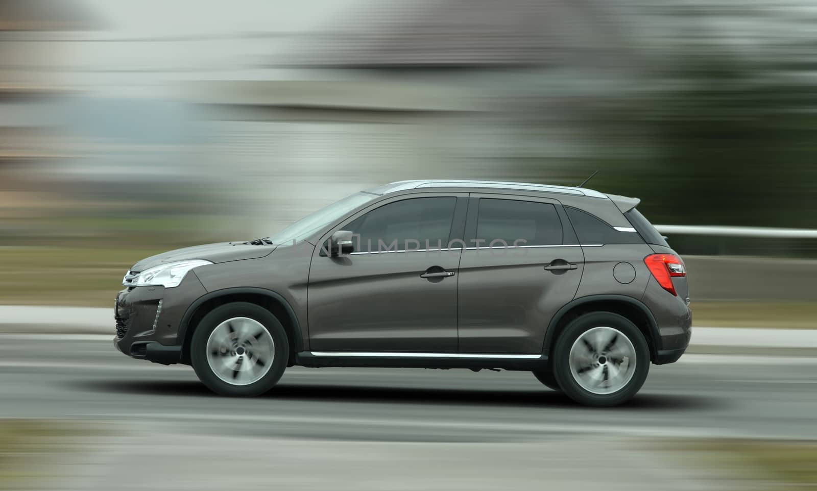 A panning shot of a speeding SUV