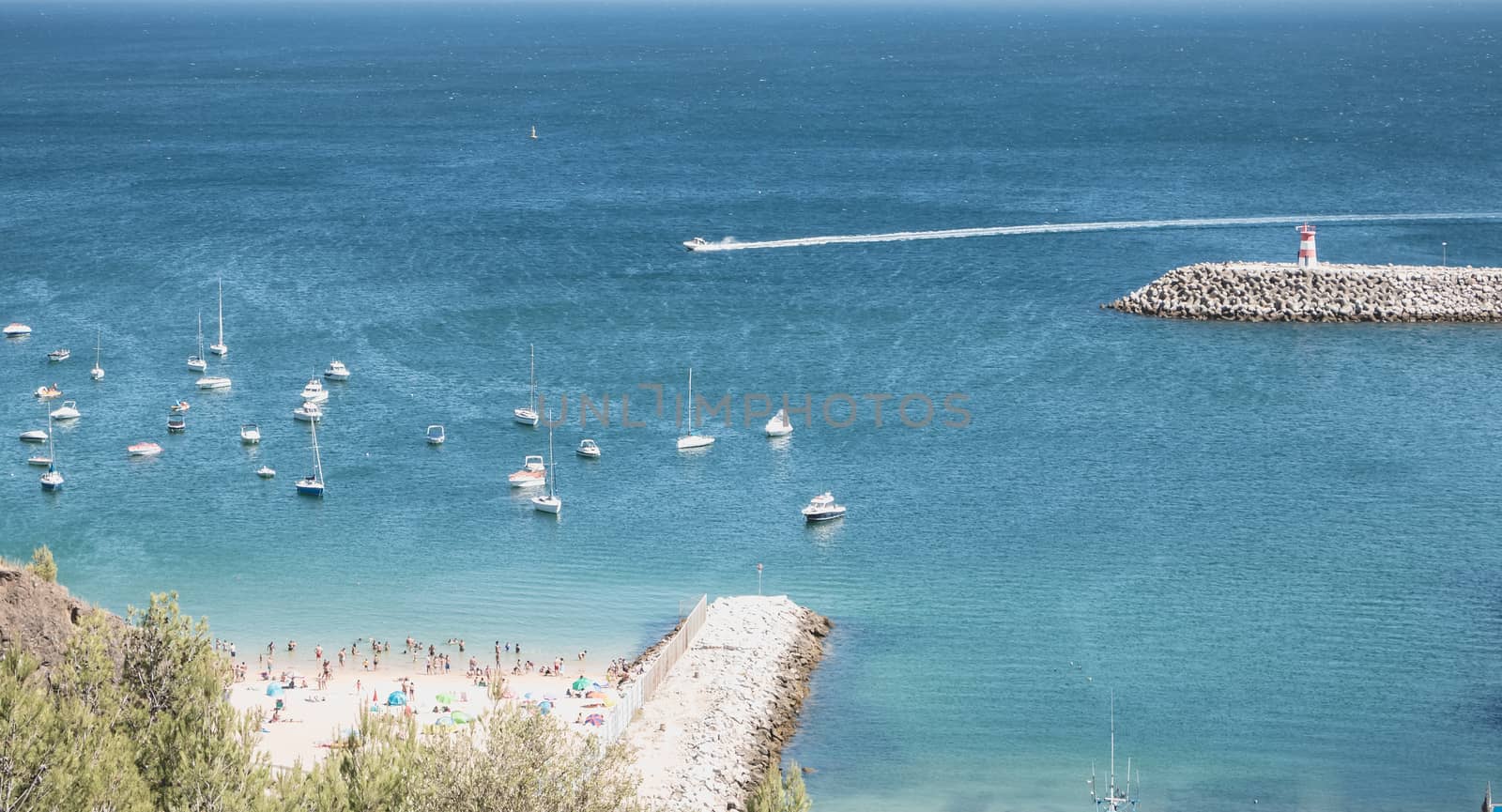 Sesimbra, Portugal - August 8, 2018: aerial overview of beaches and beach town center where tourists come to enjoy the sea on a summer day