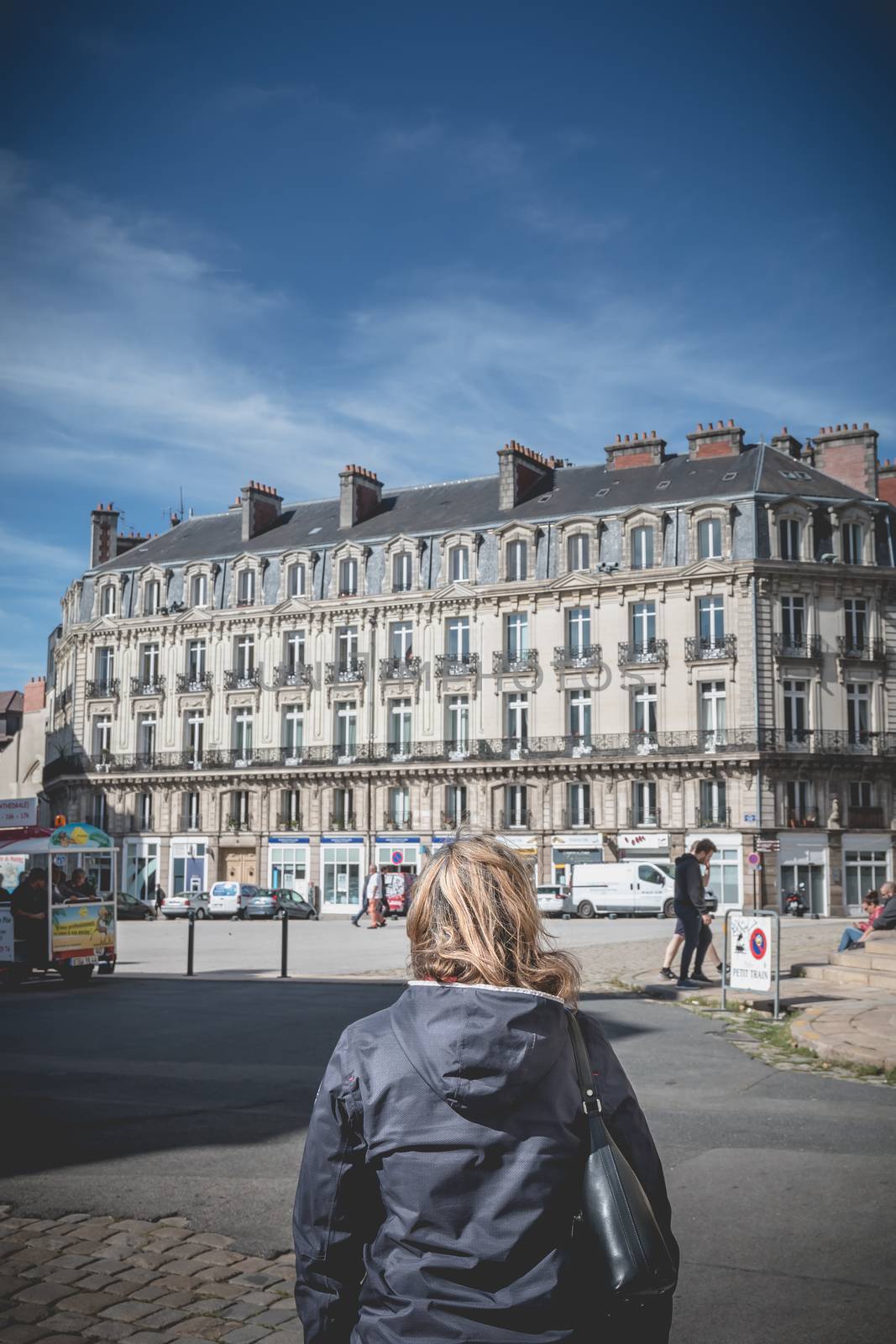 Woman walking Nantes cathedral square one at the end of summer by AtlanticEUROSTOXX
