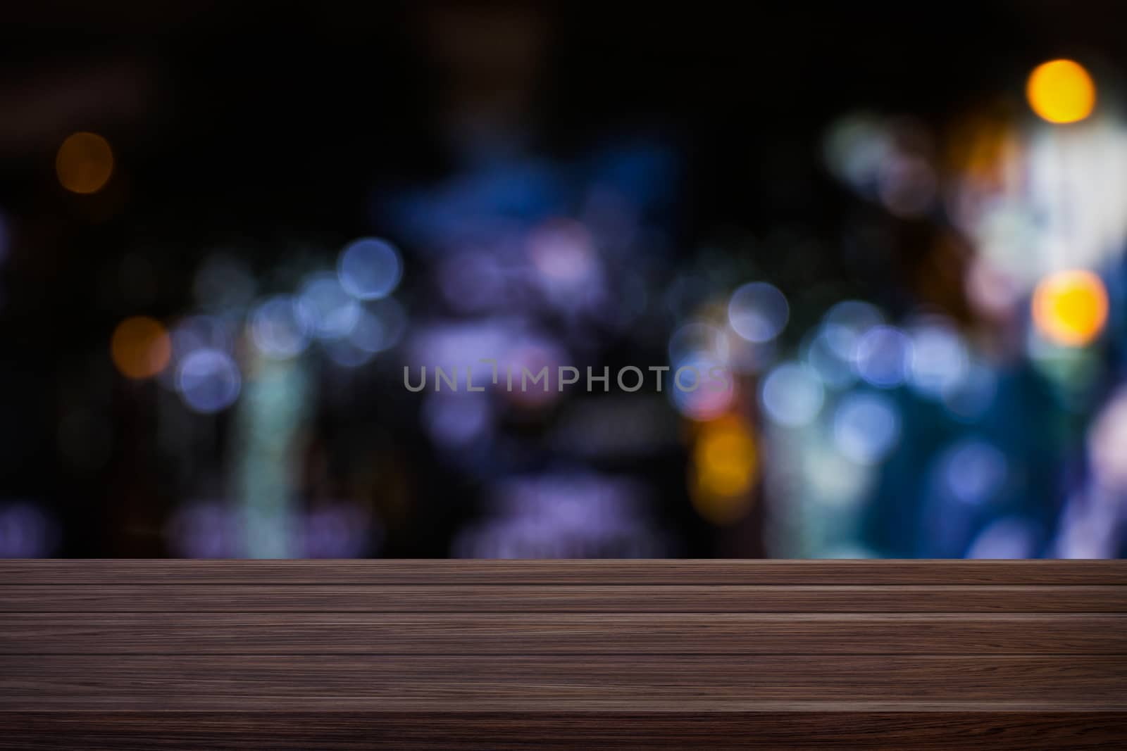 Blur cafe restaurant or coffee shop empty of dark wood table with blurred light gold bokeh abstract background for montage product display or design. by prapstock
