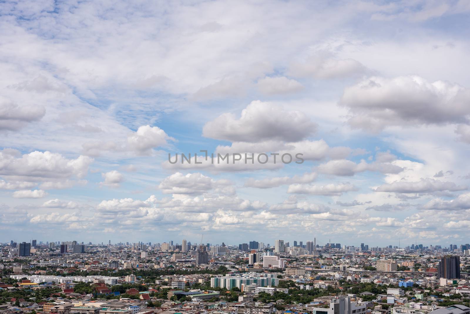 The Bangkok cityscape from skyscraper view with clouds and blue sky.