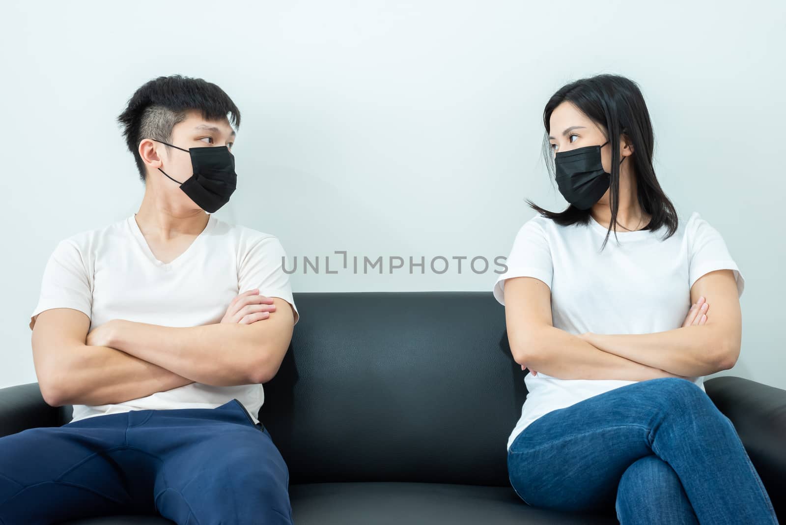 An Asian couple wearing a black mask and stays together with boring and social distancing.