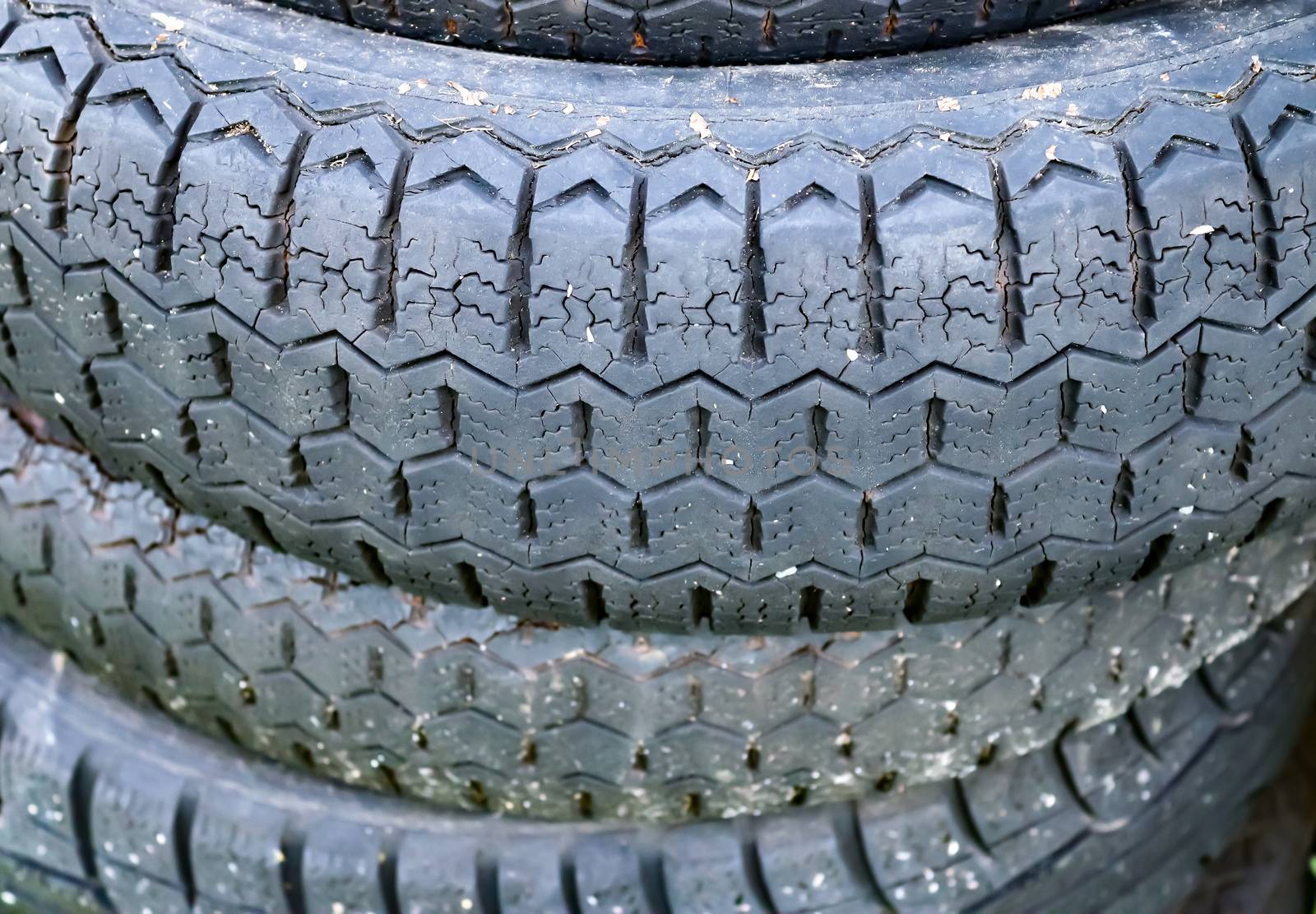 Damaged and worn old black tires on a stack. Tire tread problems. Solutions concept.
