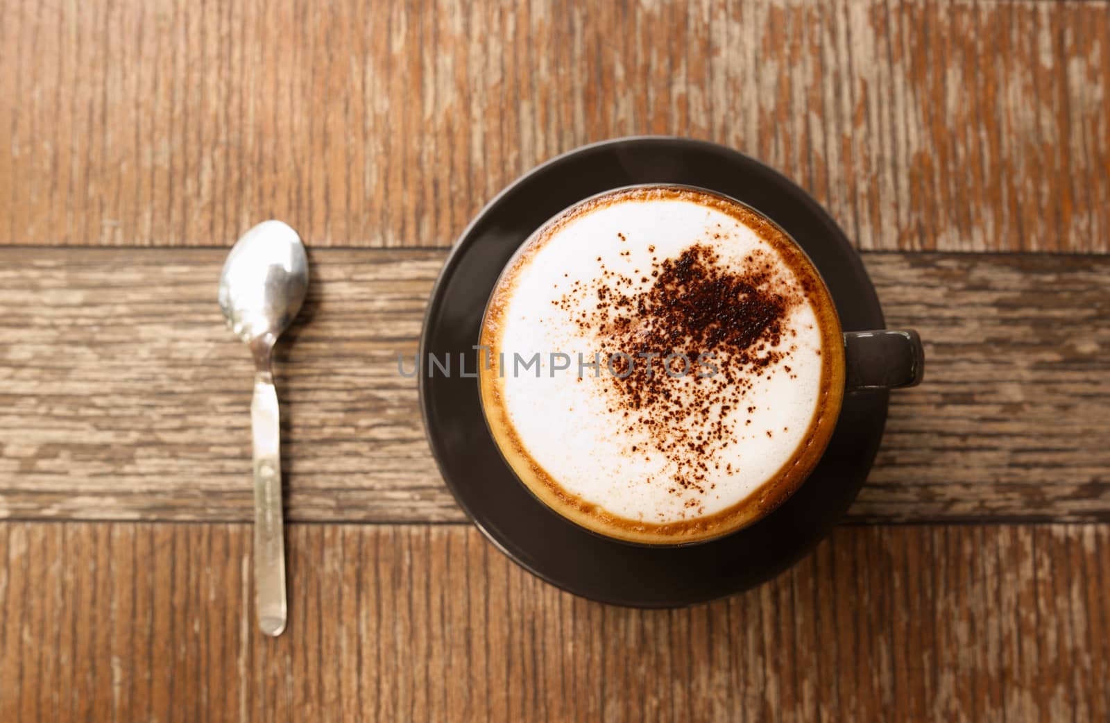 Hot mocha coffee or Cappuccino in the brown cup on the wooden table.