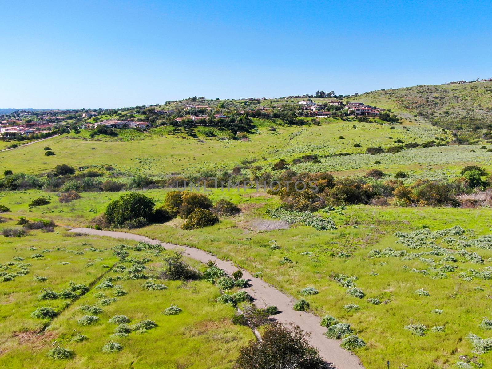 Aerial view of green valley with big luxury villa on the background in a private community, San Diego, California.