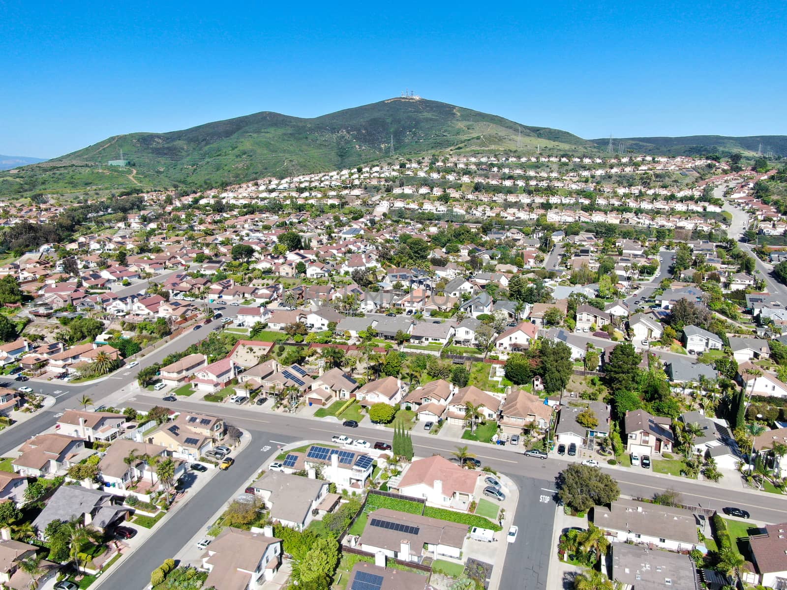 Aerial view of upper middle class neighborhood in the valley with blue sky by Bonandbon