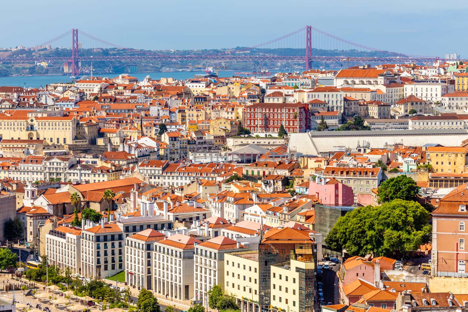 View to downtown of Lisbon with miltiple streets and houses and bridge of 25 of April in a background, Portugal