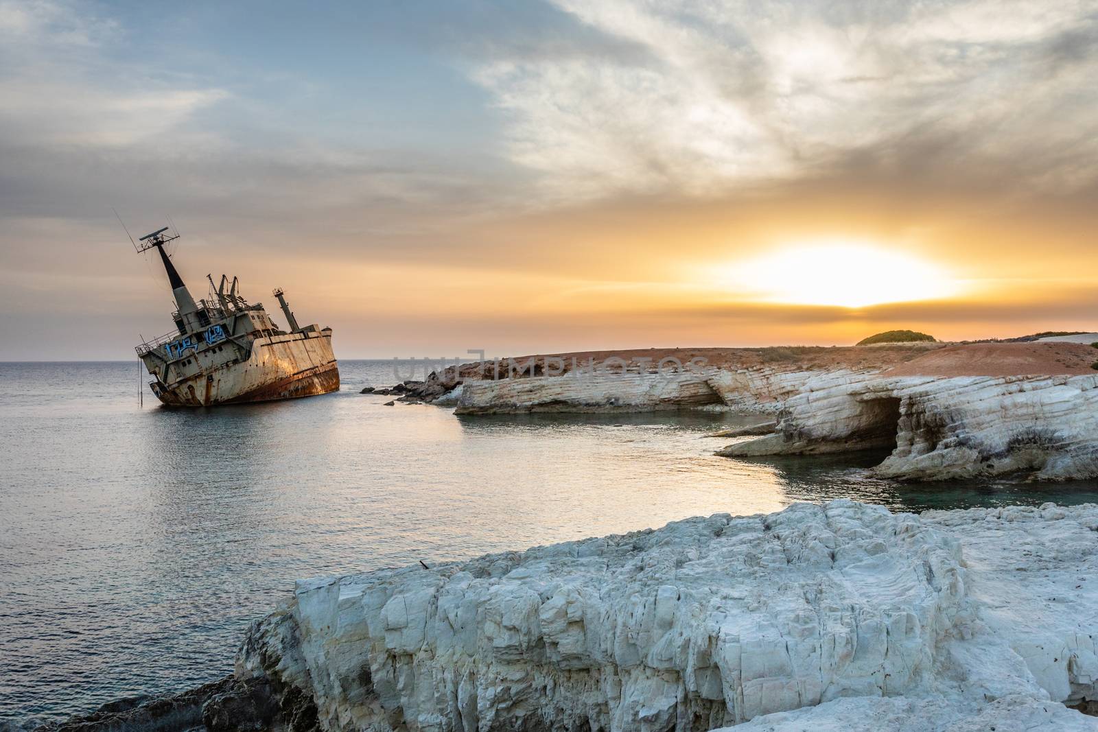 Abandoned rusty ship stranded ashore  in the sunset rays at Peyia village, Paphos