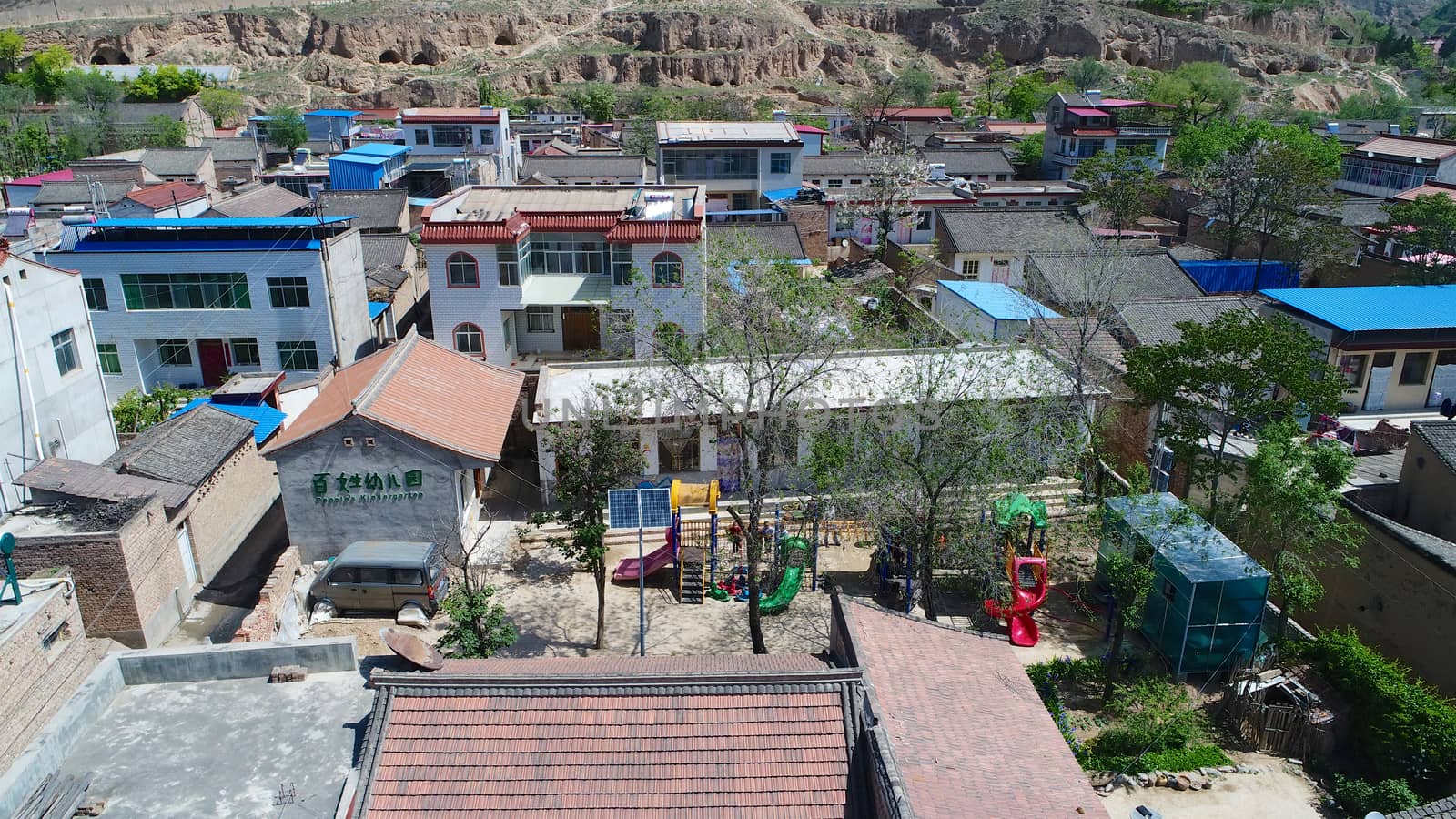 Aerial top view of small poor town houses in Gansu, China by Bonandbon