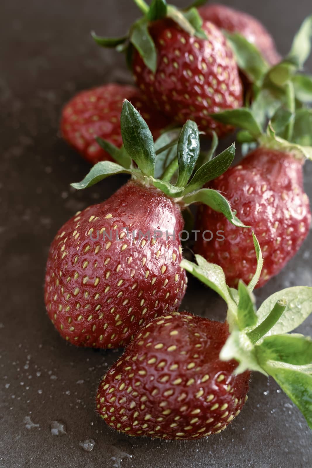On a black background ripe red strawberry berries close-up.