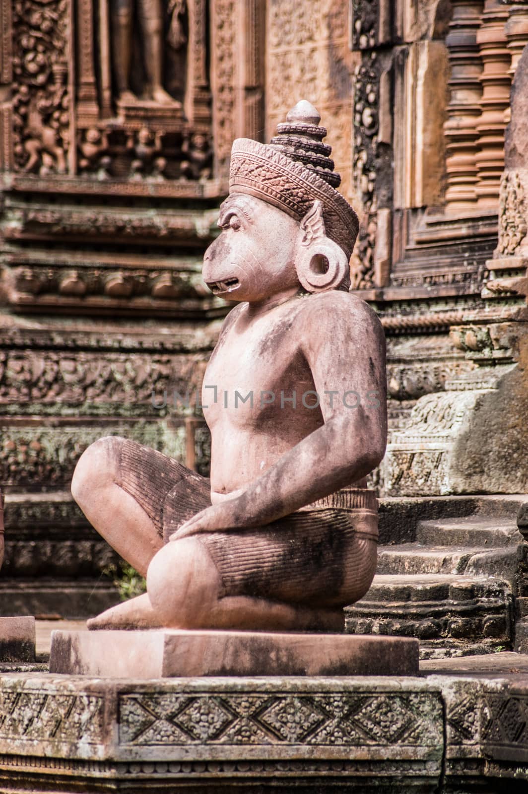 Ancient Khmer carved statue of a monkey soldier, part of Hanuman's army, guarding a prasat chapel at Banteay Srei Temple, Angkor, Cambodia.