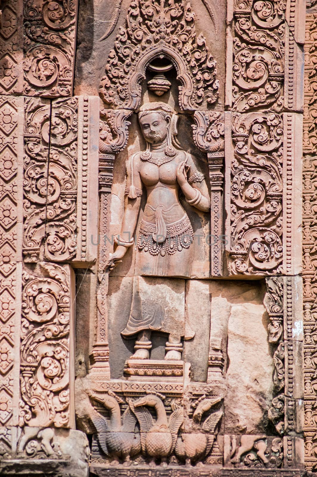 Ancient Khmer bas relief carving of a devata goddess with a gaggle of geese on a Prasat at Banteay Srei Temple, Angkor, Cambodia. Sandstone carving over 1000 years old.