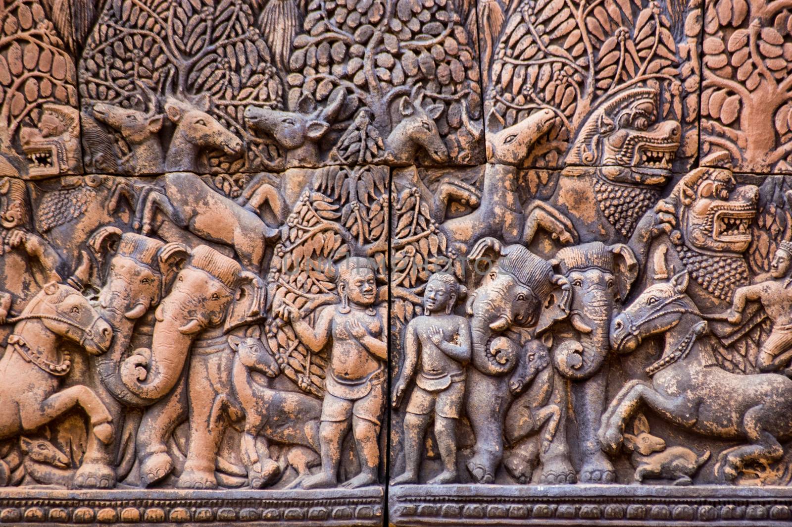 Ancient Khmer carving of Krishna and his brother Balarama with the animals of the forest. North library at Banteay Srei Temple, Angkor, Cambodia.