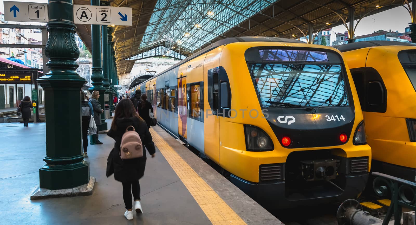 Interior of Porto train station where people walk on the dock by AtlanticEUROSTOXX