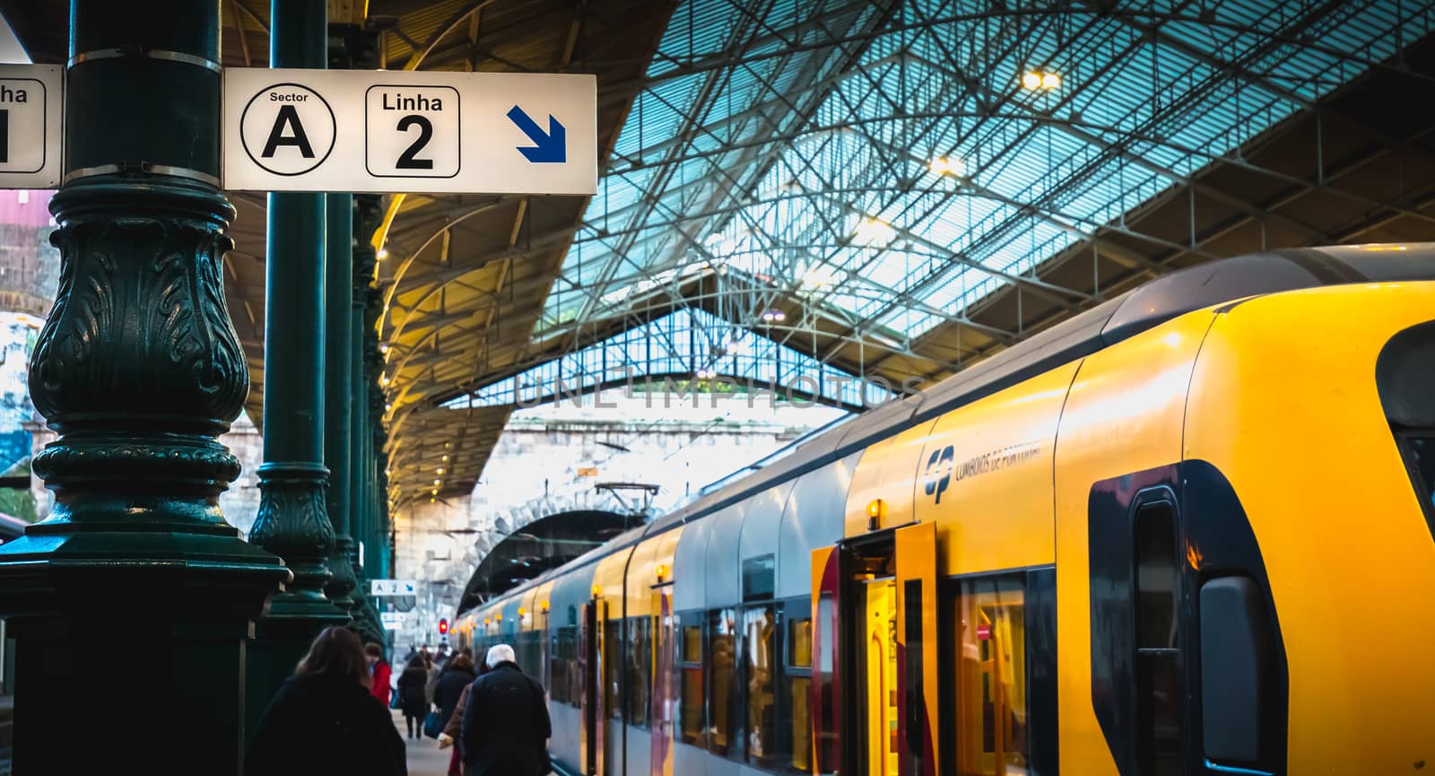 Interior of Porto train station where people walk on the dock by AtlanticEUROSTOXX