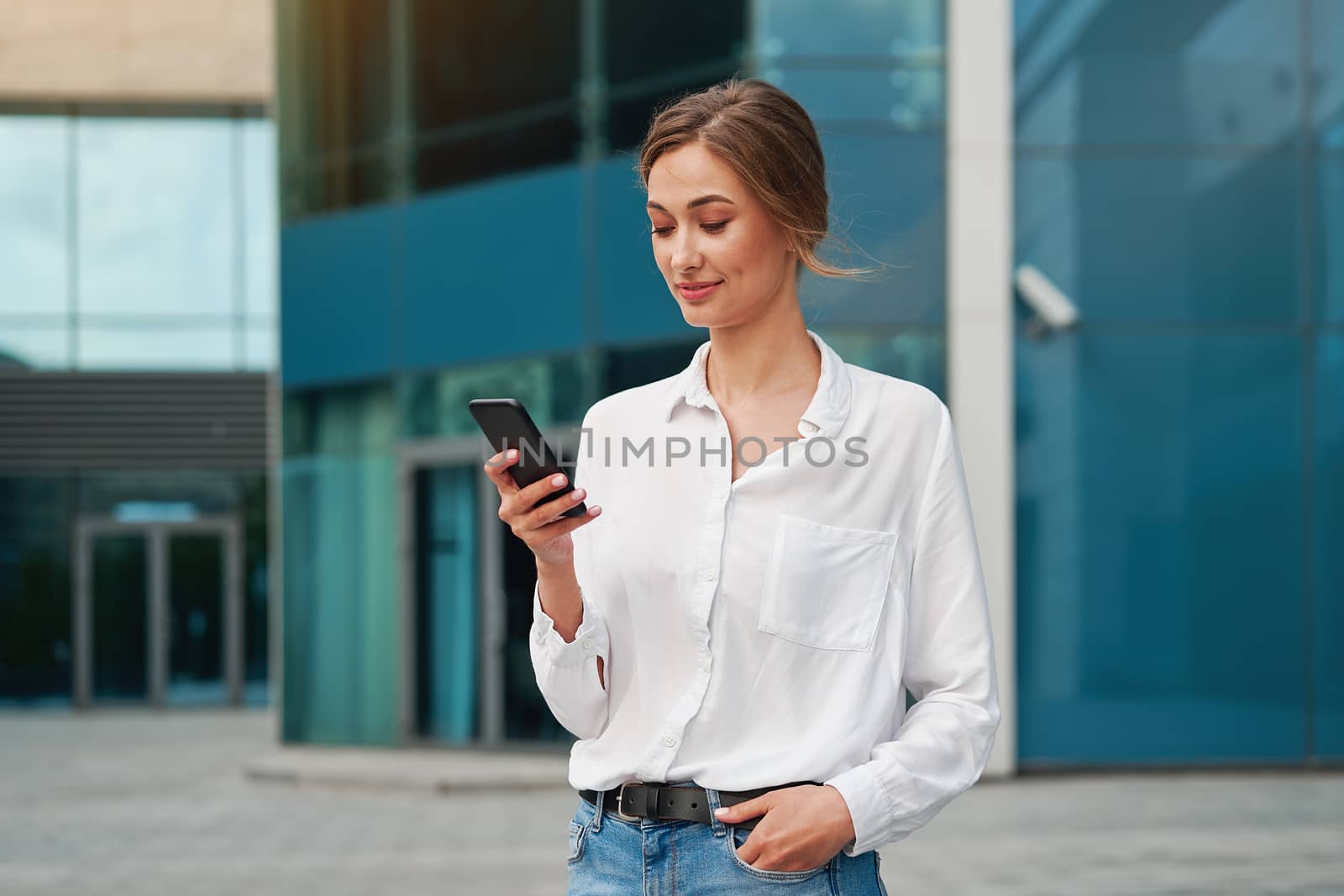 Businesswoman successful woman business person standing outdoor corporate building exterior cell phone Pensive elegance cute caucasian professional business woman middle age dreaming with mobile phone