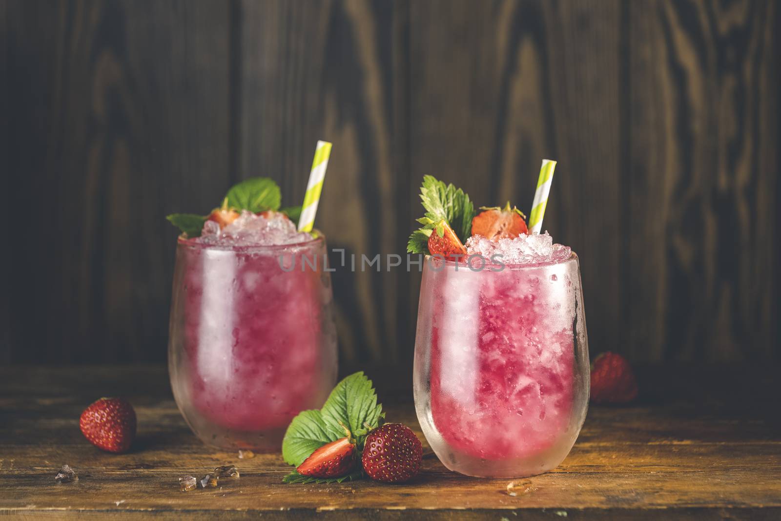Strawberry drink with ice. Two glass of strawberry ice drink with ripe berry on wooden turquoise table surface. Alcoholic nonalcoholic summer fresh drink beverage	