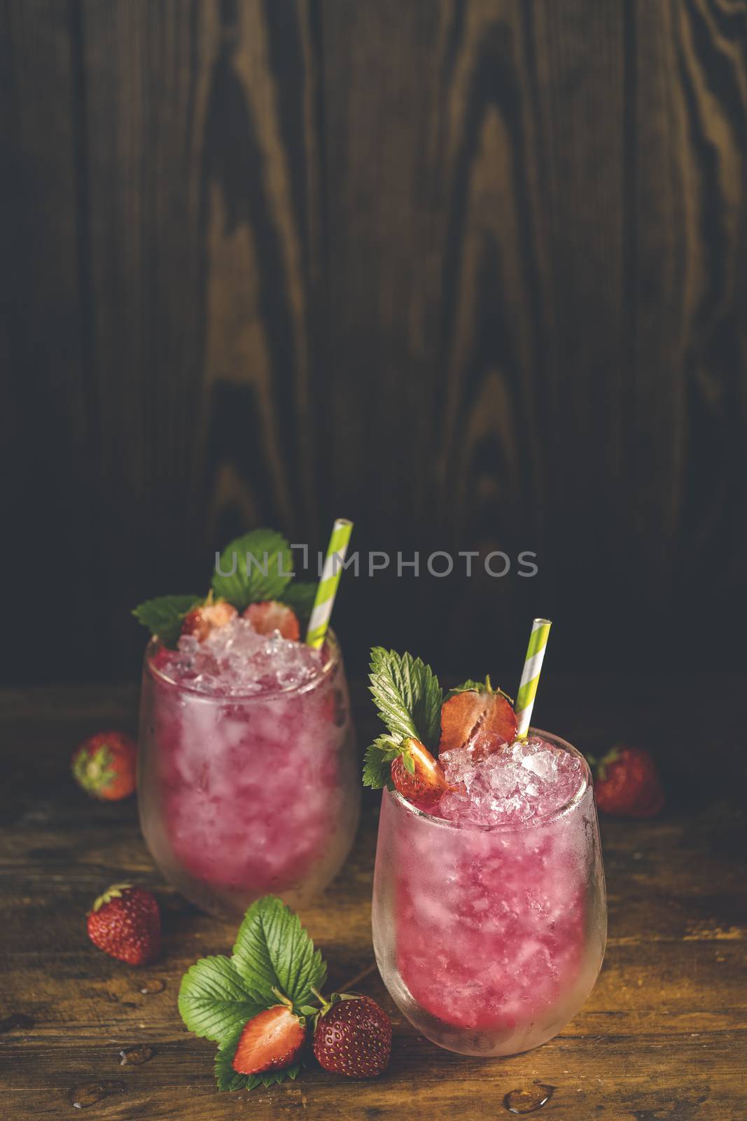 Strawberry drink with ice. Two glass of strawberry ice drink with ripe berry on wooden turquoise table surface. Alcoholic nonalcoholic summer fresh drink beverage	