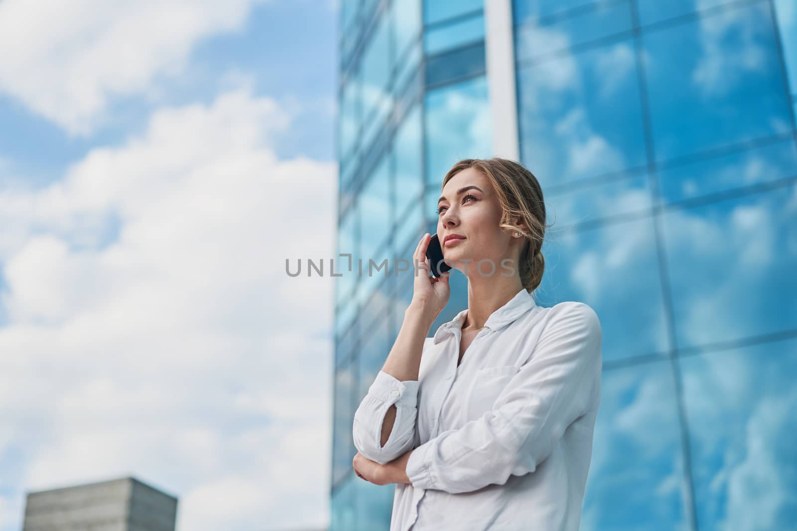 Businesswoman successful woman business person standing outdoor corporate building exterior cell phone Pensive elegance cute caucasian professional business woman middle age dreaming with mobile phone