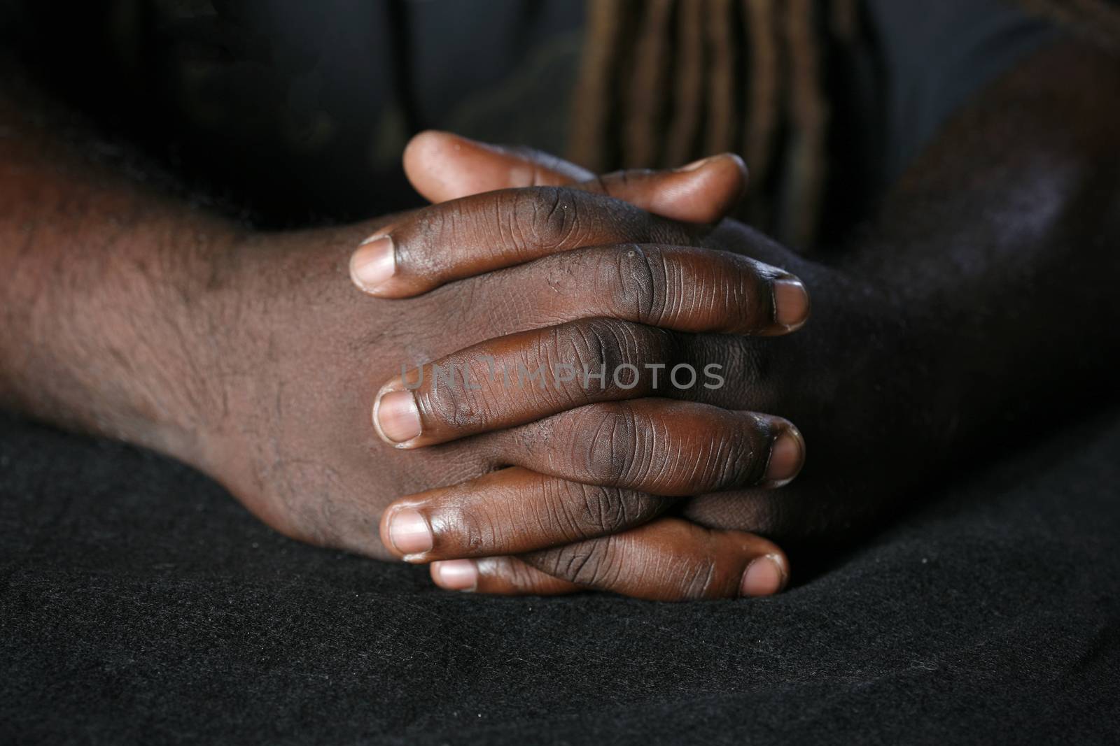 Conceptual image of Hands of African-American man and dreadlocks hairstyle background