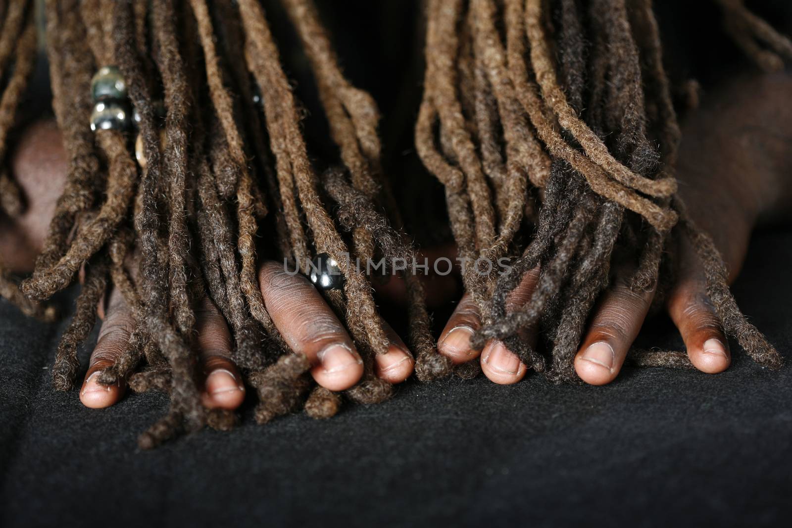 Close up of hands of African-American man holding dreadlocks