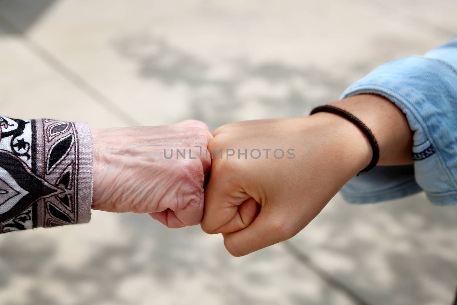 Young and old woman are fist bumping, young and old ethnic contest