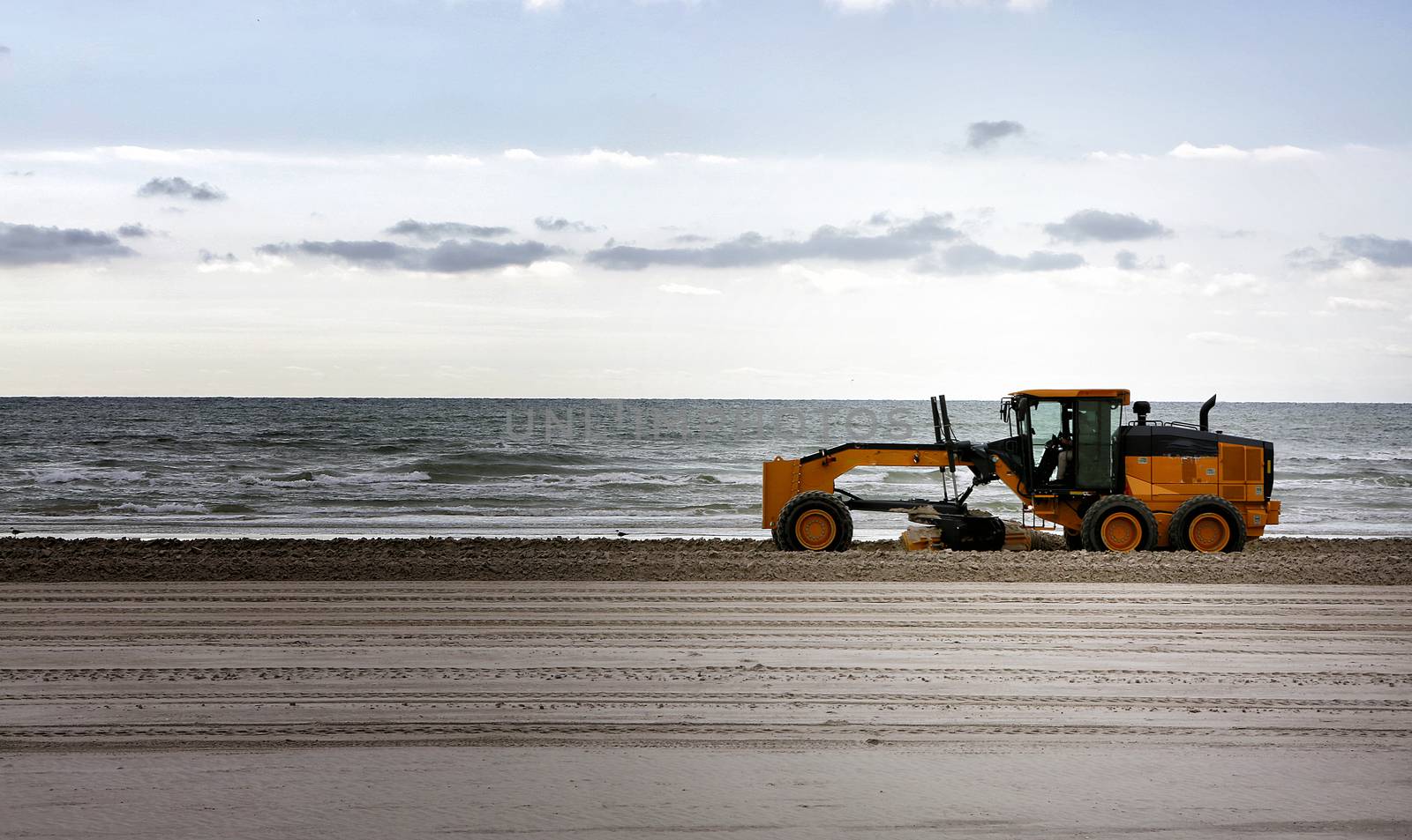 Gulf of Mexico, Padre Island, Texas. Grader adjusting send level on the beach. Beach Maintenance.