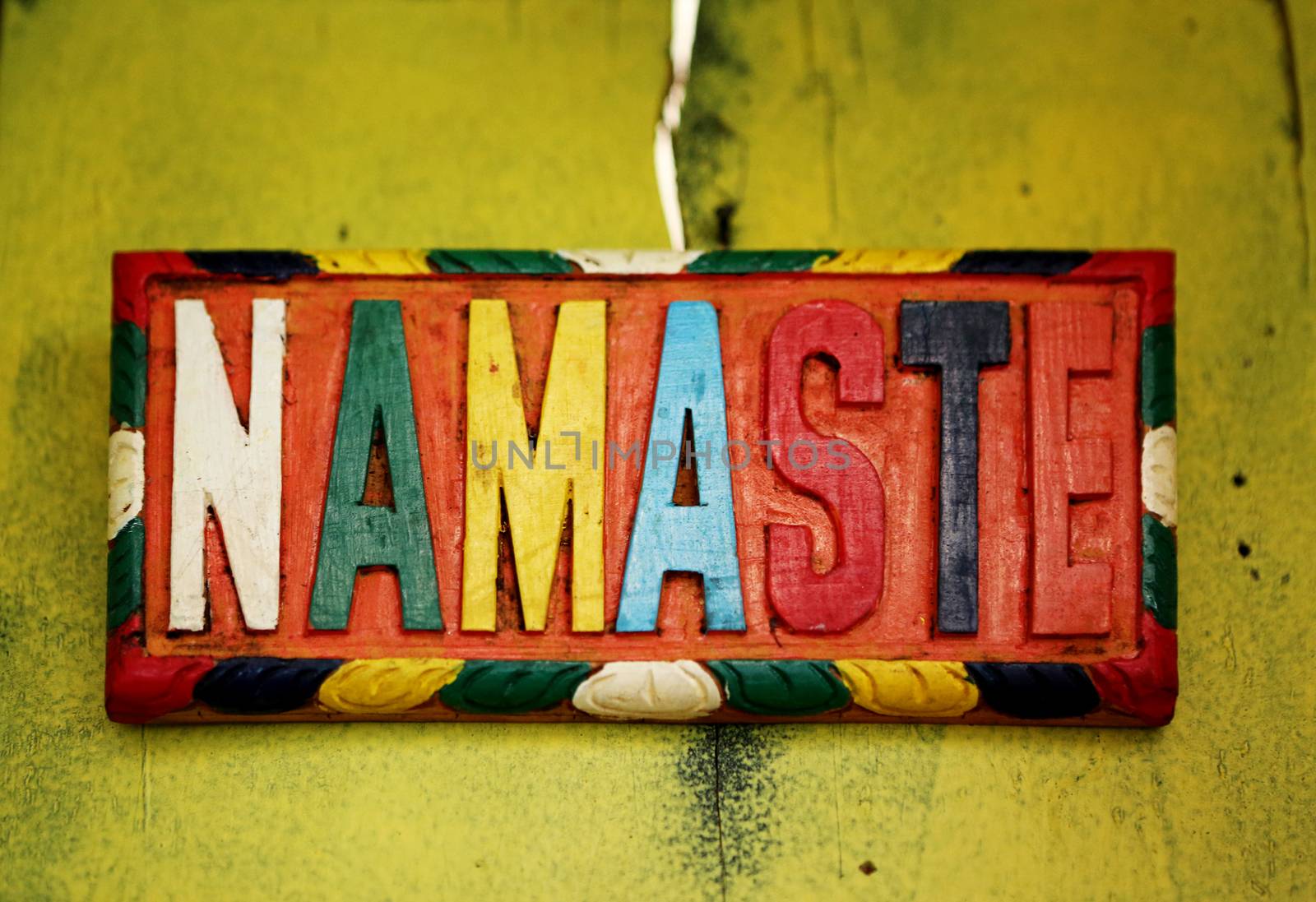 Colorful sign NAMASTE – the Sanskrit salutation - on old rustic wall