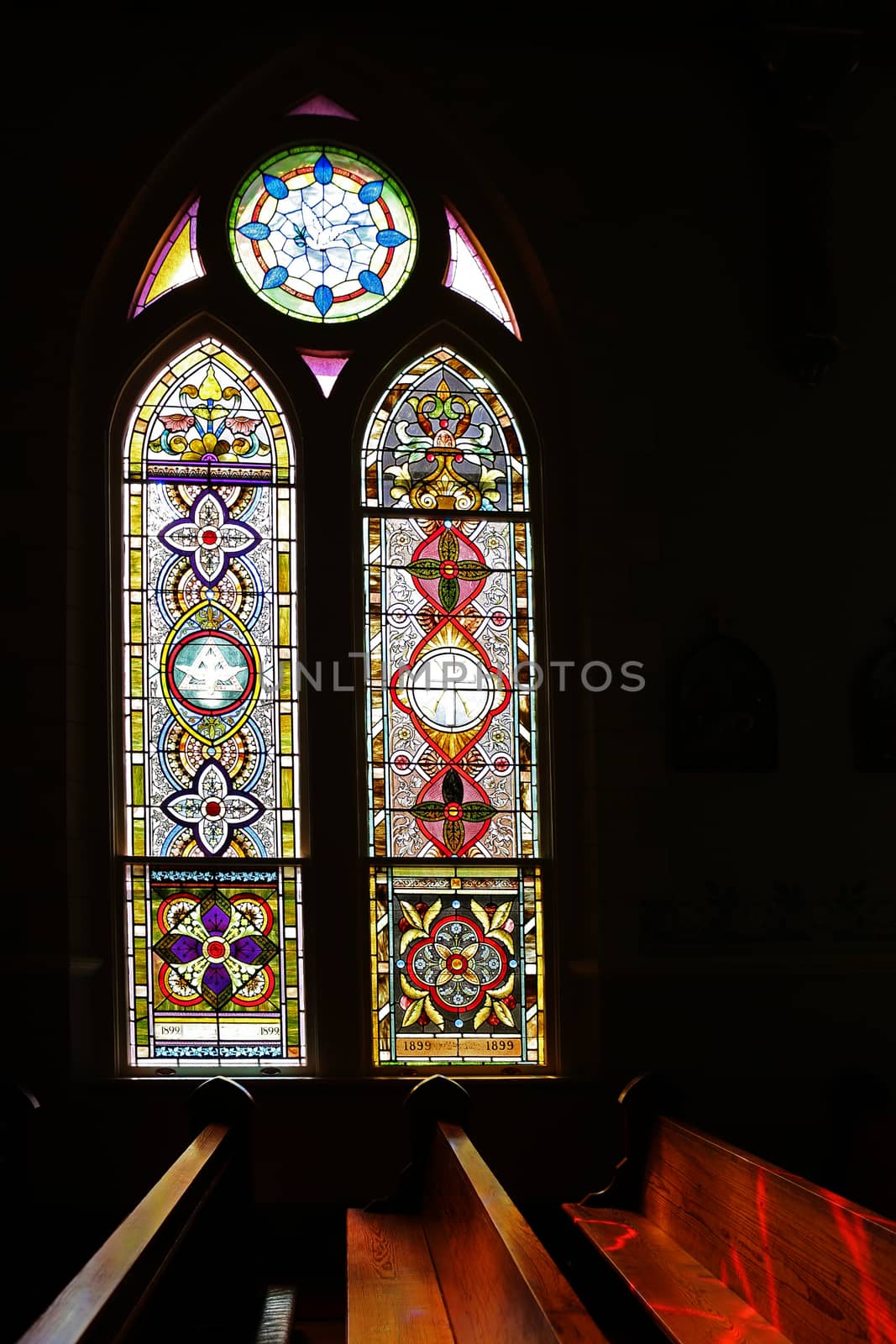 Light shining though stained-glass high gothic window.