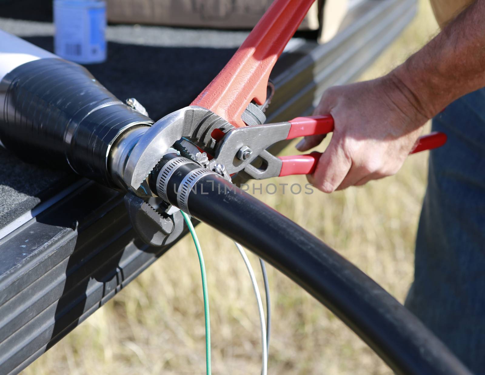 Close up of plumbers hands mounting new submersible water pump